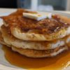 Allergy-friendly cornmeal pancakes topped with vegan butter and maple syrup