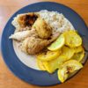 Roast chicken plated with potatoes, rice, and vegetables