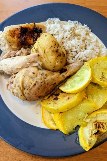 Roast chicken plated with potatoes, rice, and vegetables