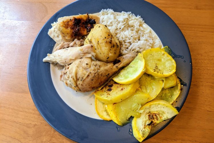 Roast chicken plated with potatoes, rice, and vegetables